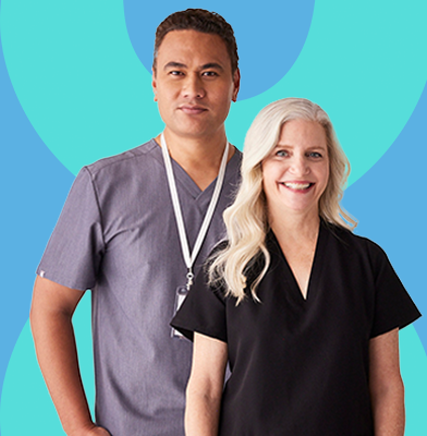 Two nurses standing together smiling and looking like they want to help